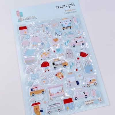 Folha de autocolantes variados coloridos com desenhos de objetos e veículos sobre fundo azul claro