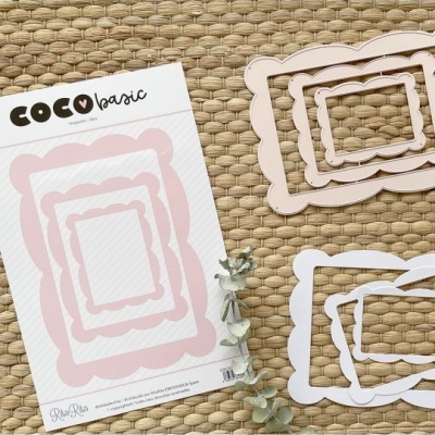 Molduras decorativas rosa e branco sobre tecido bege com folhas secas