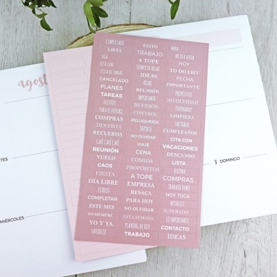 Folha adesiva rosa com palavras em espanhol sobre planner semanal e mensal
