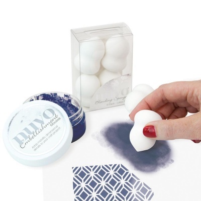 Esponjas brancas para maquilhagem e recipiente azul aberto com pigmento e padrão geométrico azul