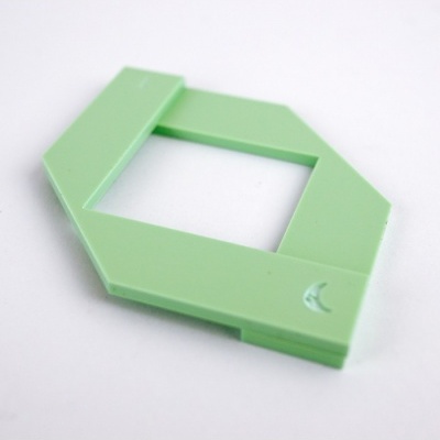 Moldura hexagonal verde claro em plástico com símbolo de lua sobre fundo branco