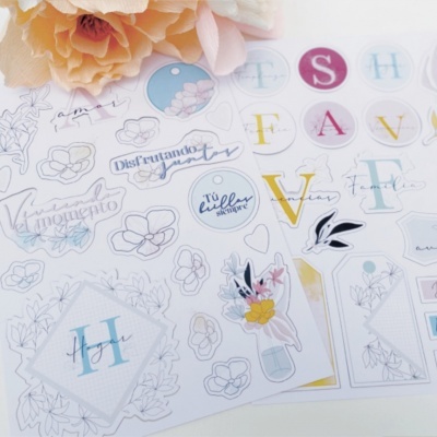 Folhas de autocolantes decorativos com texto e imagens florais sobre superfície branca com flor cor-de-rosa