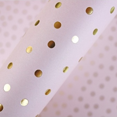 Papel de embrulho rosa com pontos dourados brilhantes