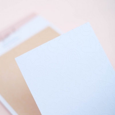 Folha branca com padrão em relevo de corações