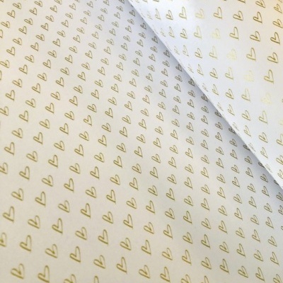 Papel de embrulho branco com corações dourados repetidos