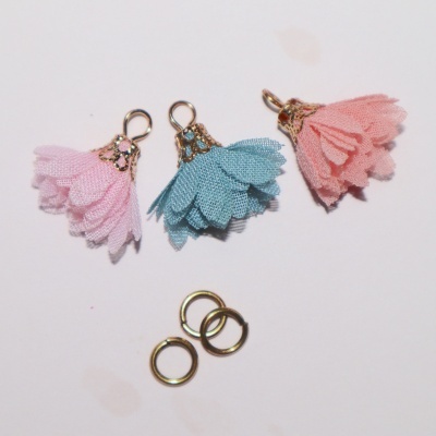 Três pendentes florais de tecido em rosa claro, azul e rosa escuro com argolas metálicas douradas