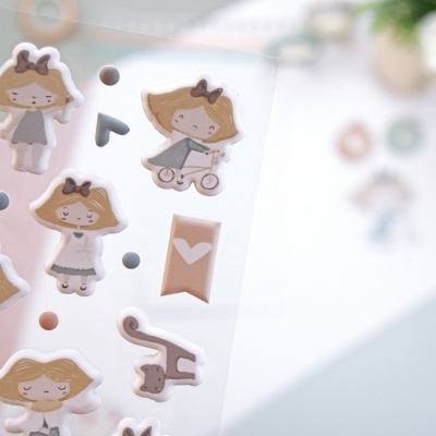 Autocolantes com personagens femininas loiras e elementos diversos, em tons claros