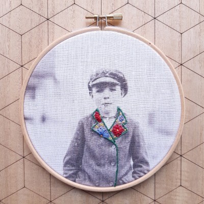 Bastidor de madeira com foto a preto e branco e bordado colorido