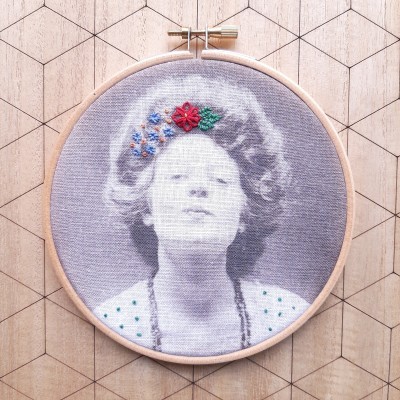 Quadro redondo de bordado com retrato monocromático de mulher e flores bordadas coloridas