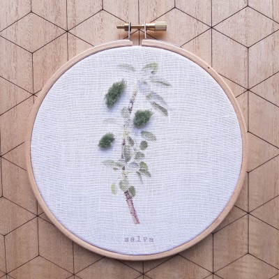 Aro de bordado com tecido branco e bordado de ramo verde e texto salve