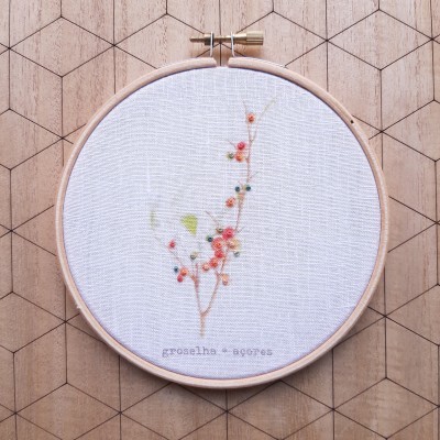 Bastidor de madeira com bordado floral delicado em linho branco