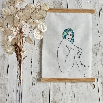 Pendente de tecido com ilustração de mulher sentada em ambiente rústico