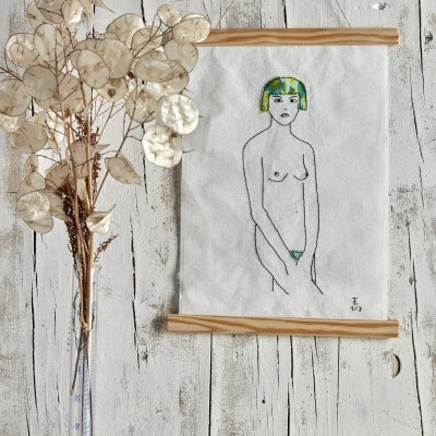 Quadro de tecido pendurado com pintura de mulher nua e vaso de ramos secos ao lado