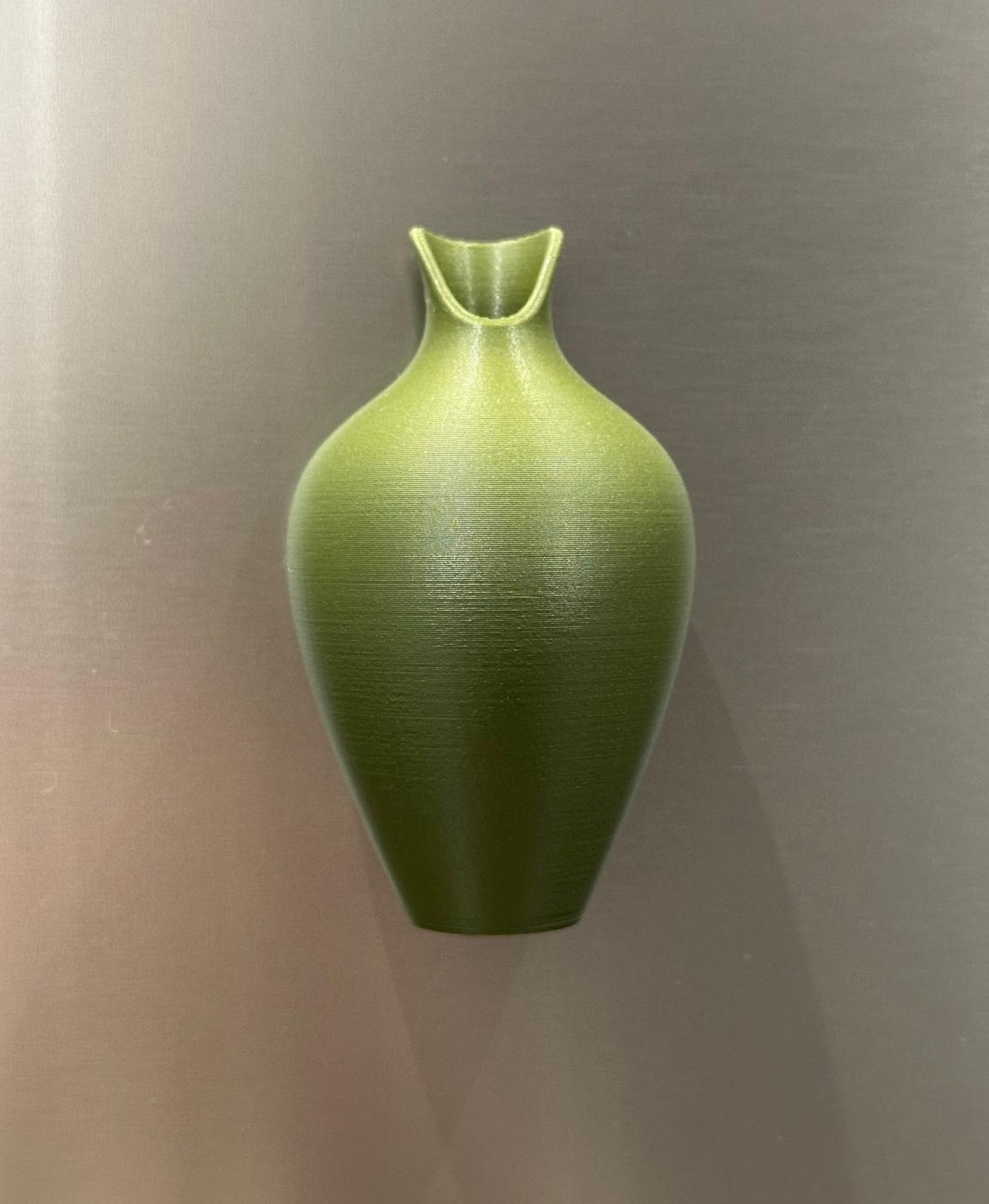 Vaso verde de cerâmica com textura sobre fundo neutro