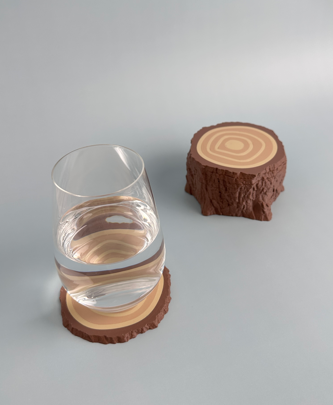 Conjunto de dois copos transparentes com suportes de tronco de árvore castanhos