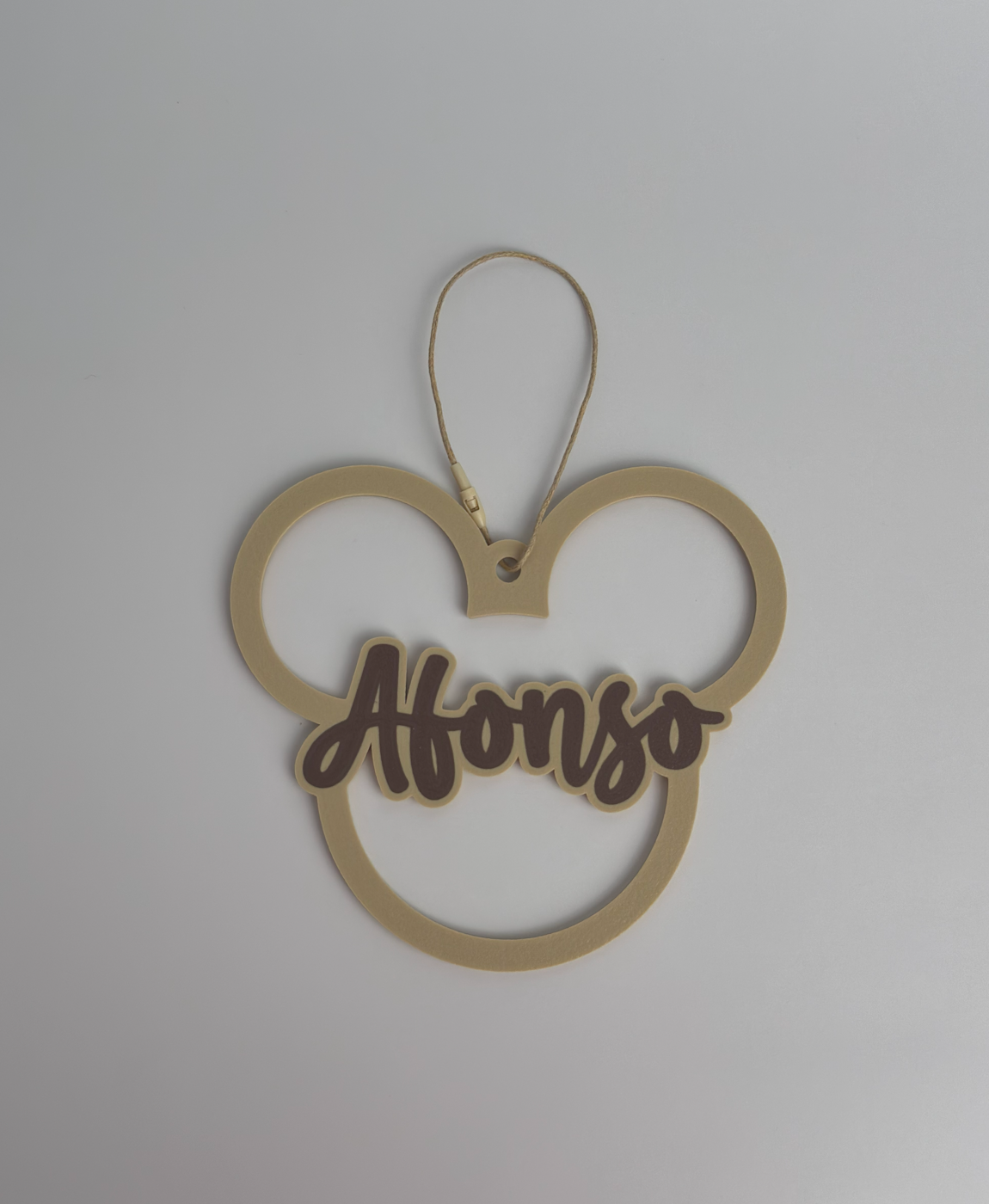 Acessório decorativo dourado em forma de cabeça de rato com o nome 'Afonso' em castanho