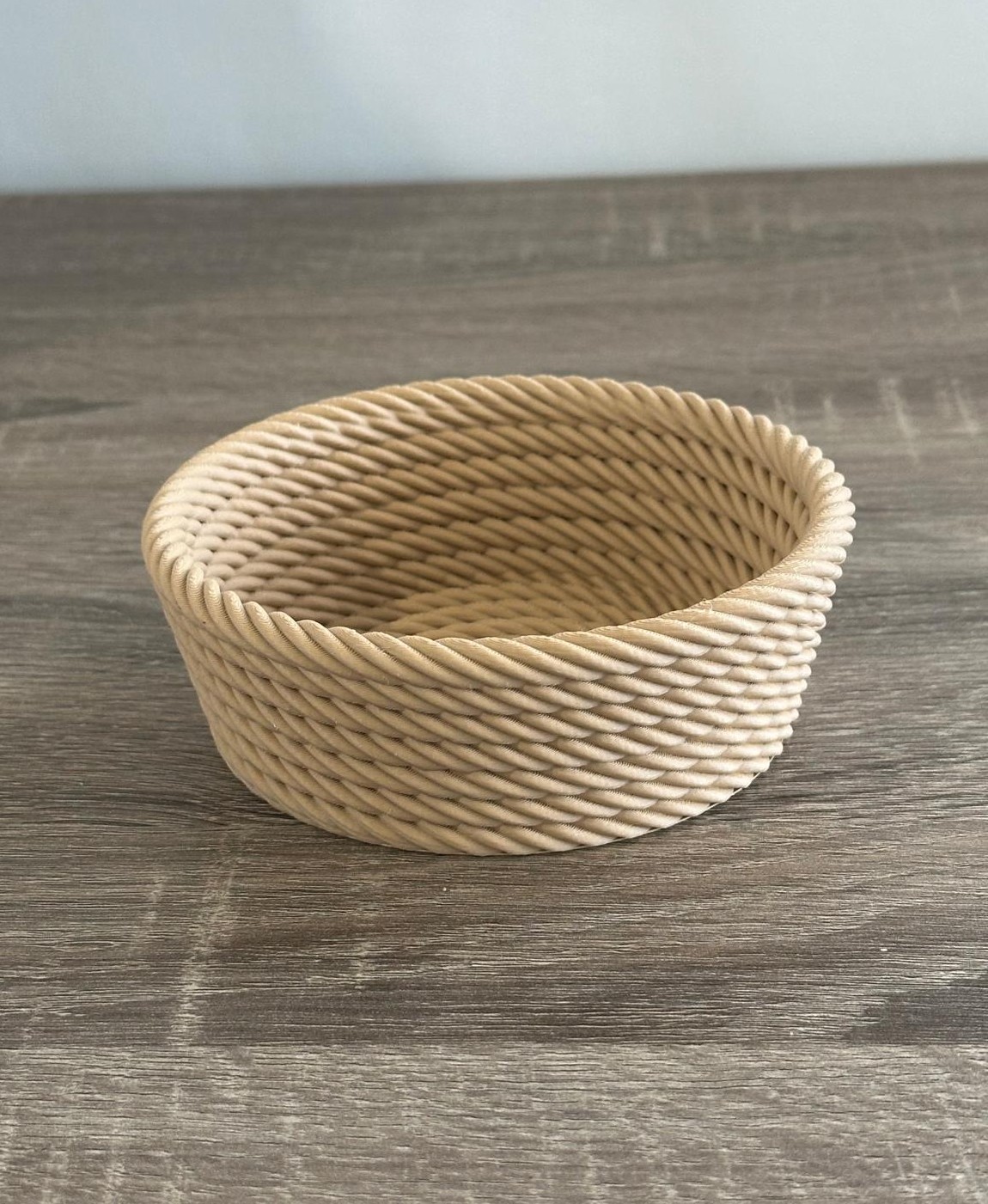 Cesto redondo de corda natural bege com textura trançada