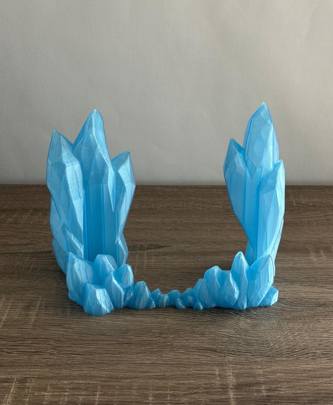 Suporte decorativo azul claro em formato de cristais sobre mesa de madeira