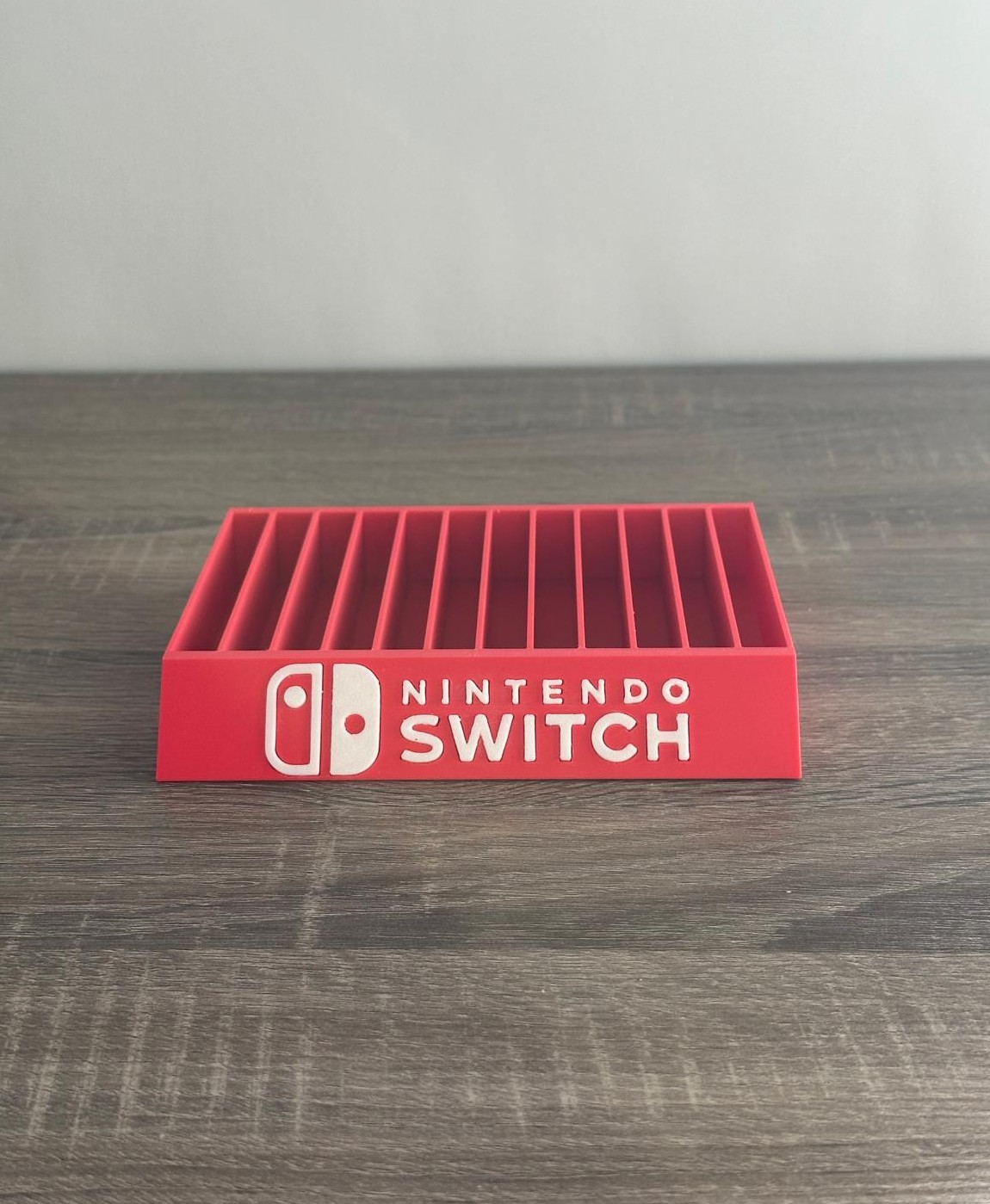 Suporte vermelho para jogos Nintendo Switch com logótipo branco