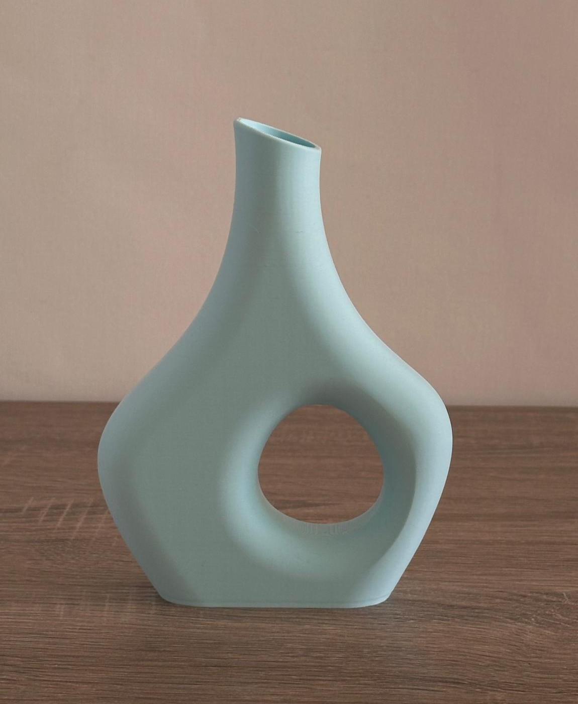 Vaso em cerâmica azul claro com design oval e buraco circular