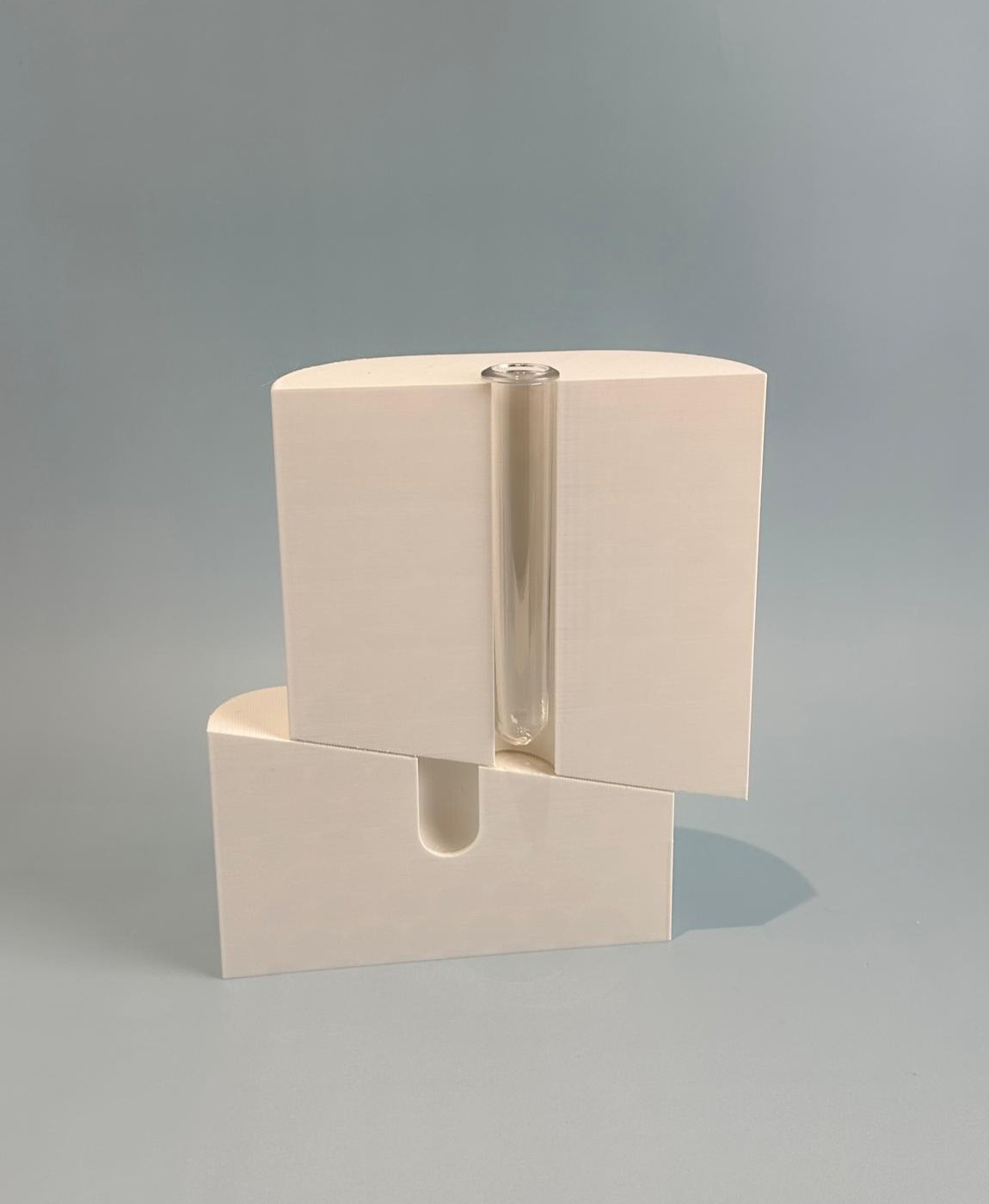 Duas caixas brancas empilhadas com um tubo de vidro transparente