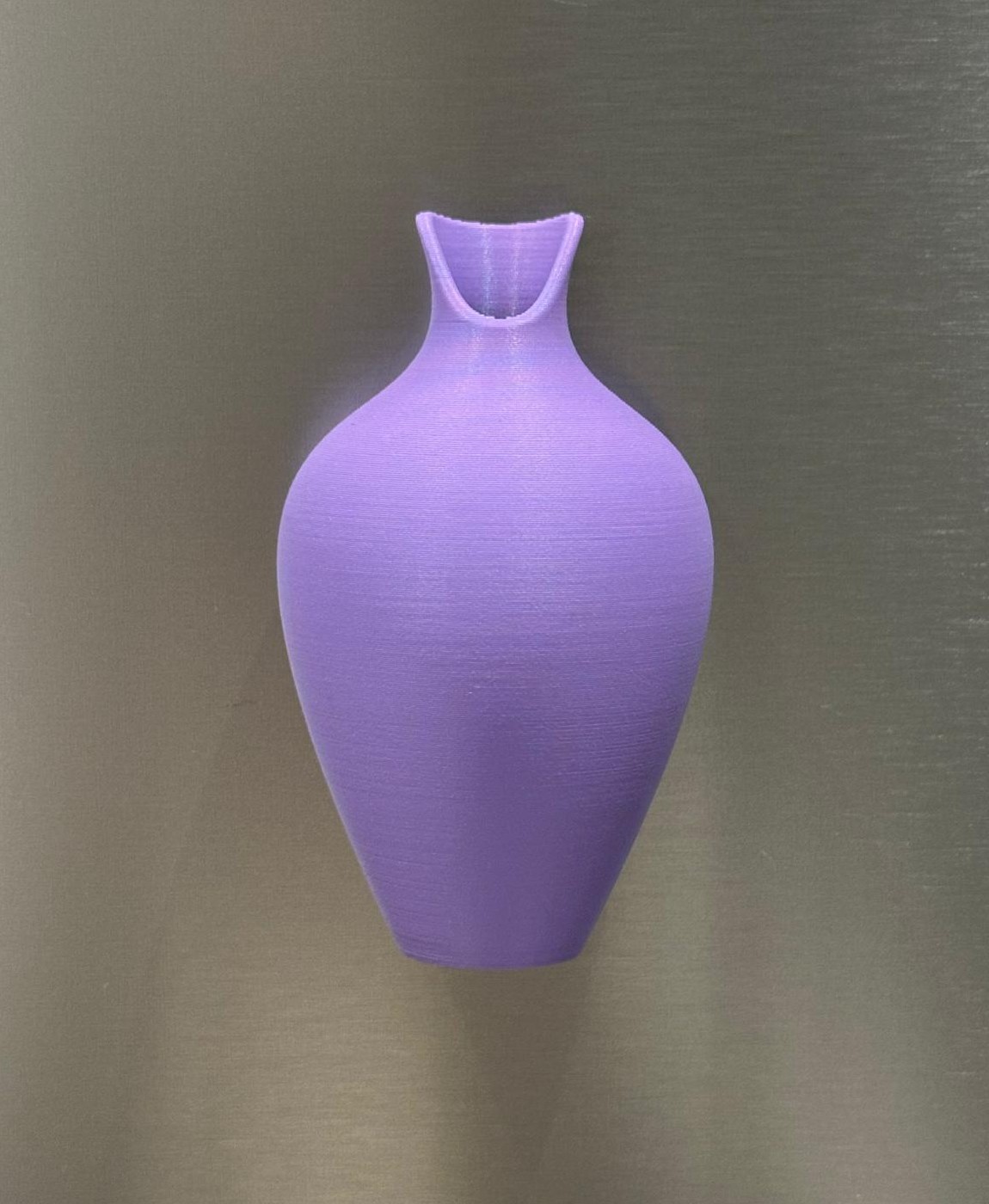 Vaso cerâmico lilás arredondado com gargalo estreito sobre fundo cinza