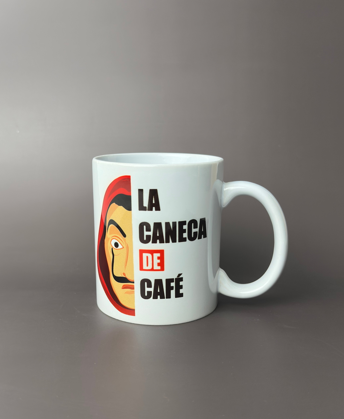 Caneca branca com ilustração e texto 'LA CANECA DE CAFÉ'.