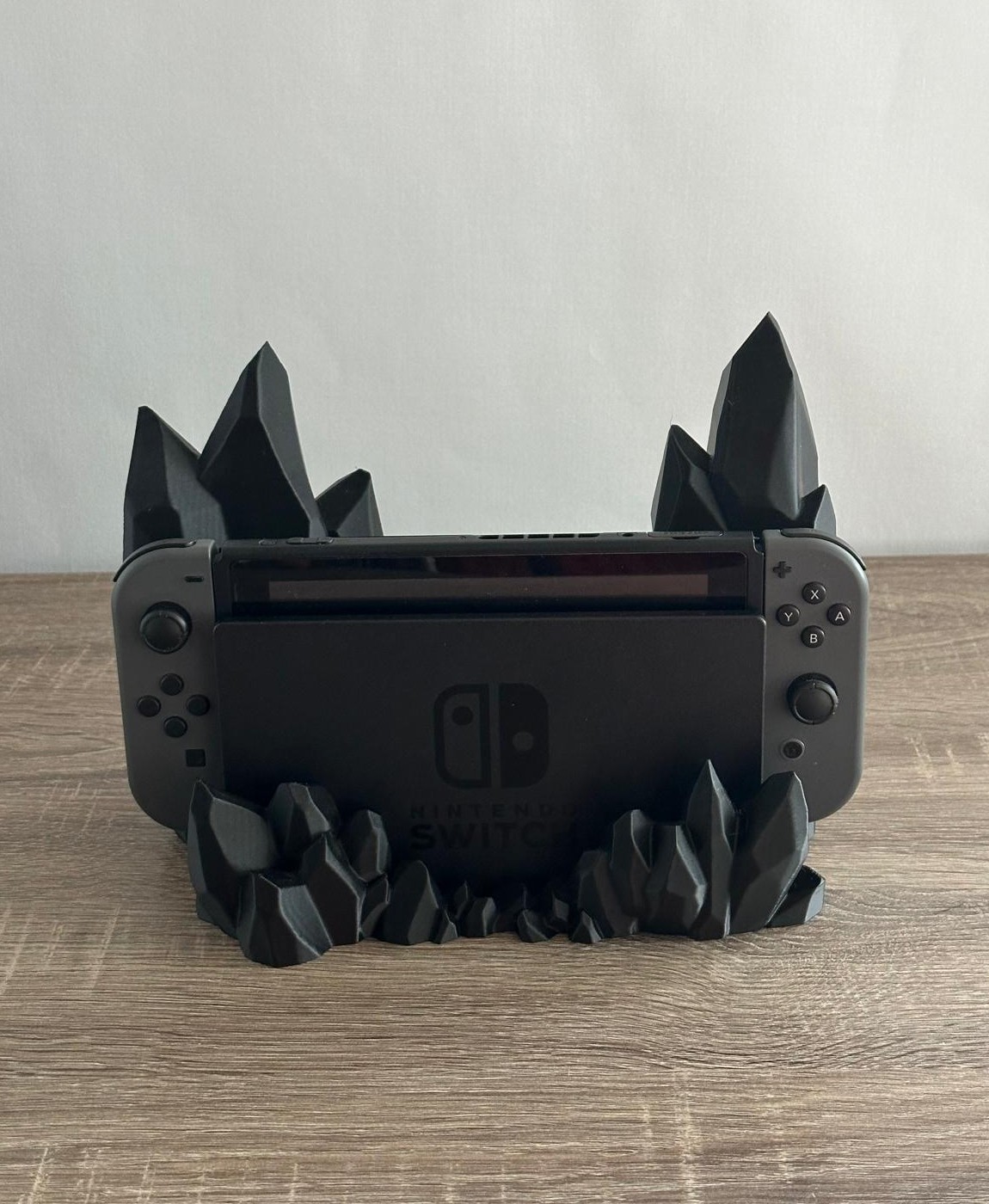 Consola Nintendo Switch em suporte preto com design de cristais