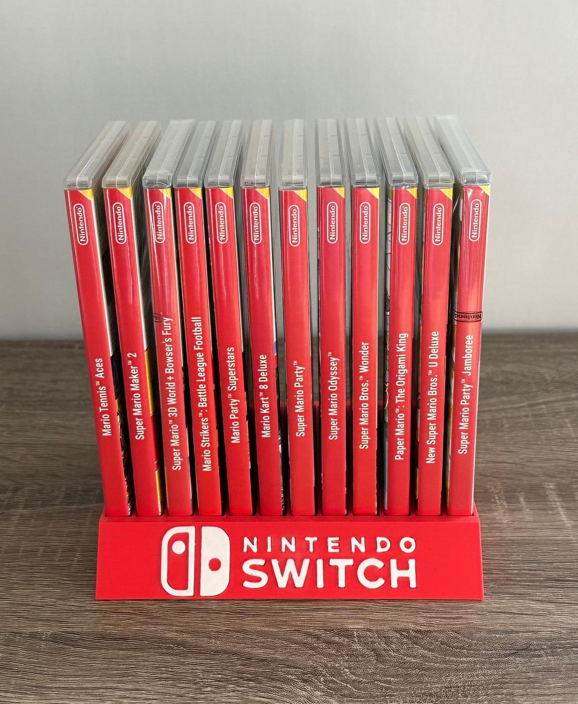Jogos Nintendo Switch organizados num suporte vermelho com logótipo Nintendo Switch