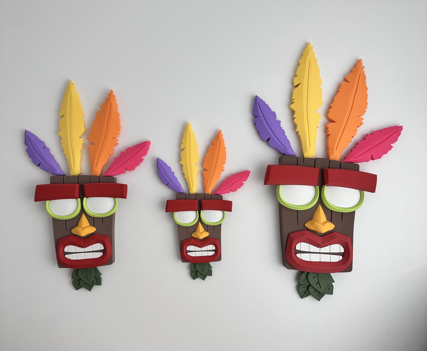 Máscaras tribais decorativas coloridas com penas e detalhes na parede