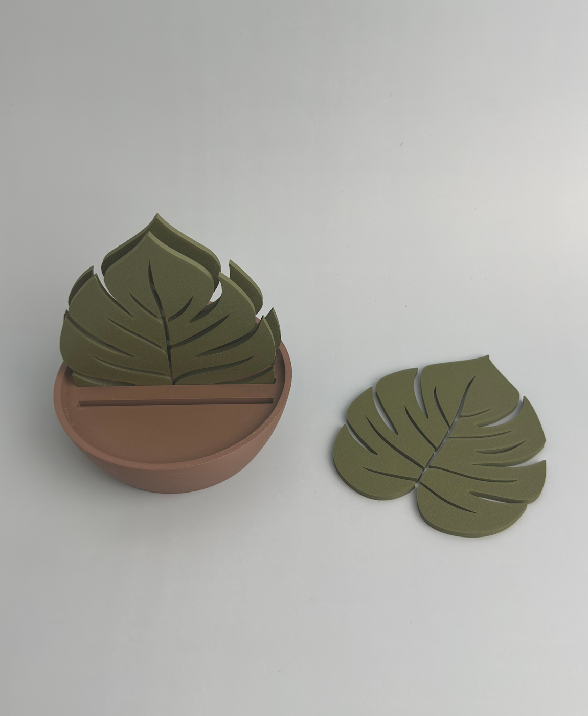 Suporte castanho com folhas verdes decorativas em fundo branco