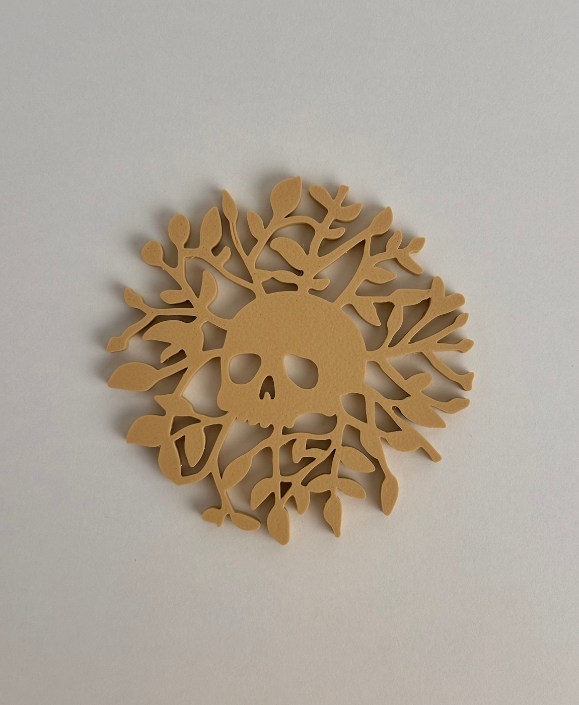 Adorno em madeira com design de crânio e plantas em padrão circular bege