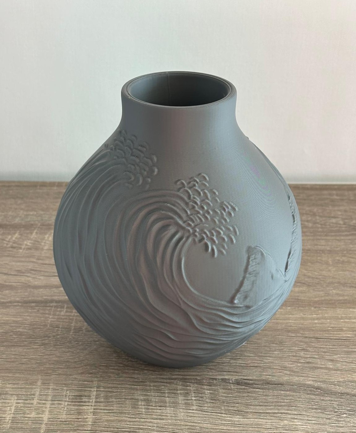 vaso cinzento em cerâmica com relevo de ondas e surfista