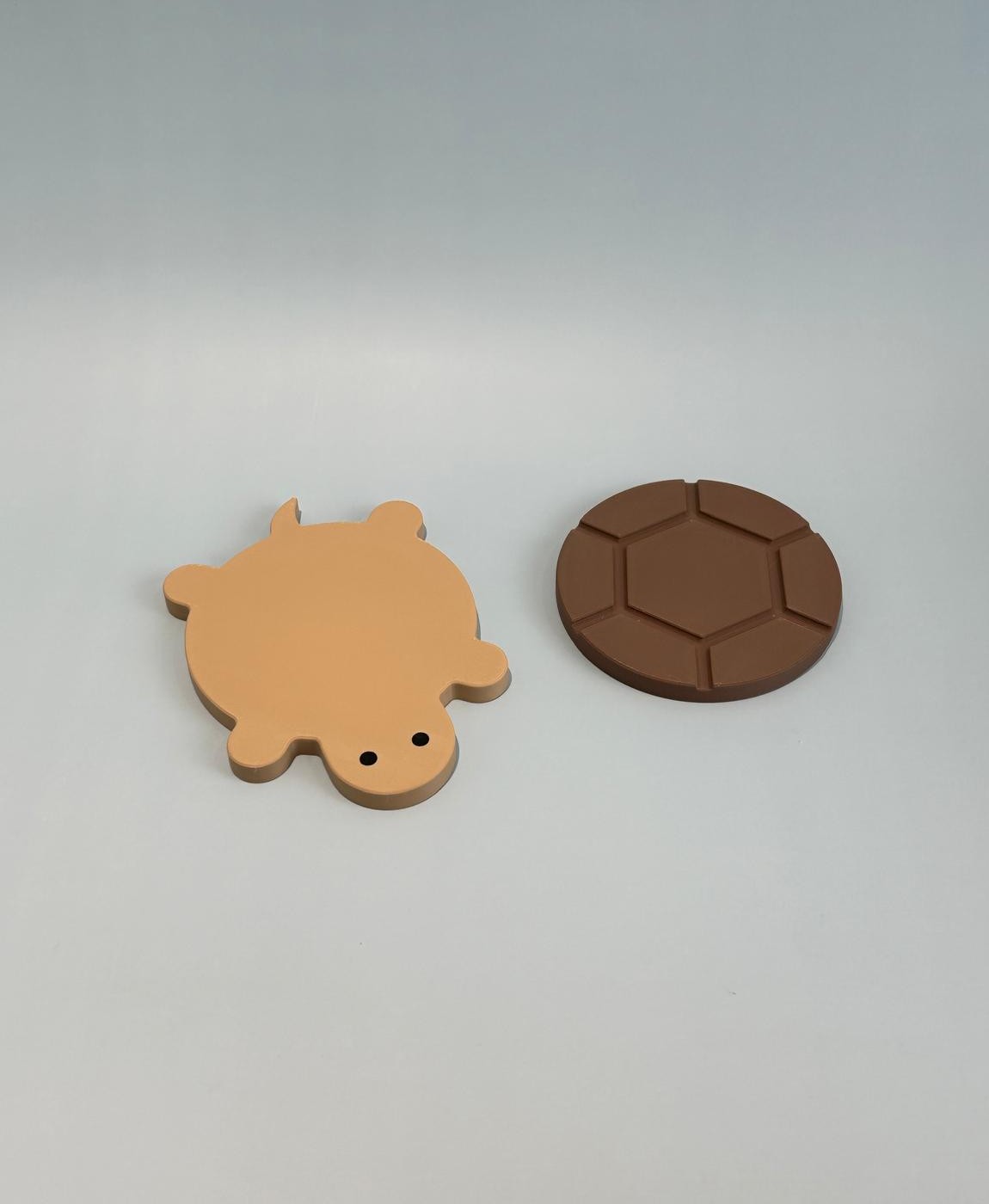 Suportes em forma de tartaruga bege e castanha sobre fundo branco