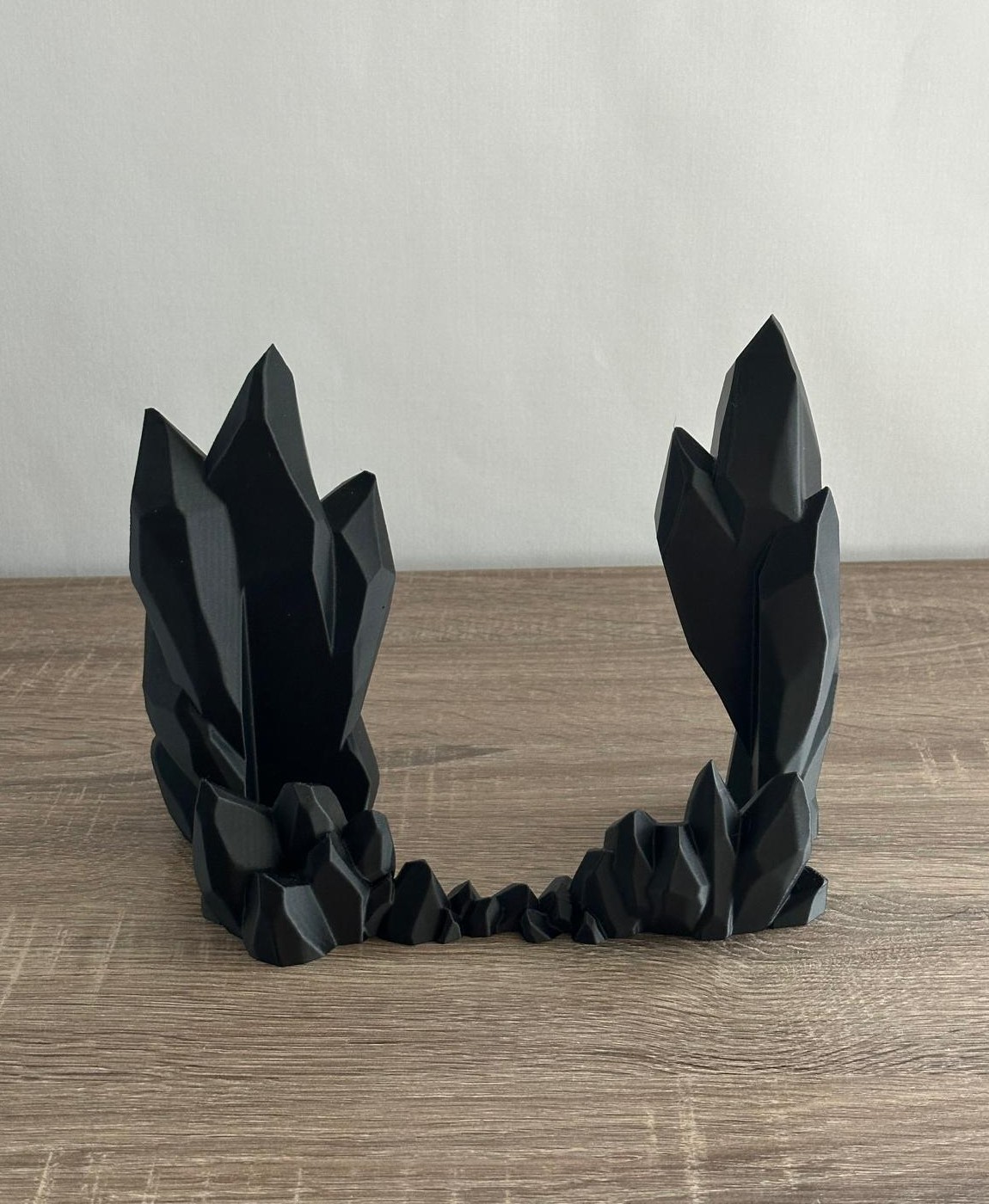 Escultura decorativa preta em forma de cristais em madeira clara