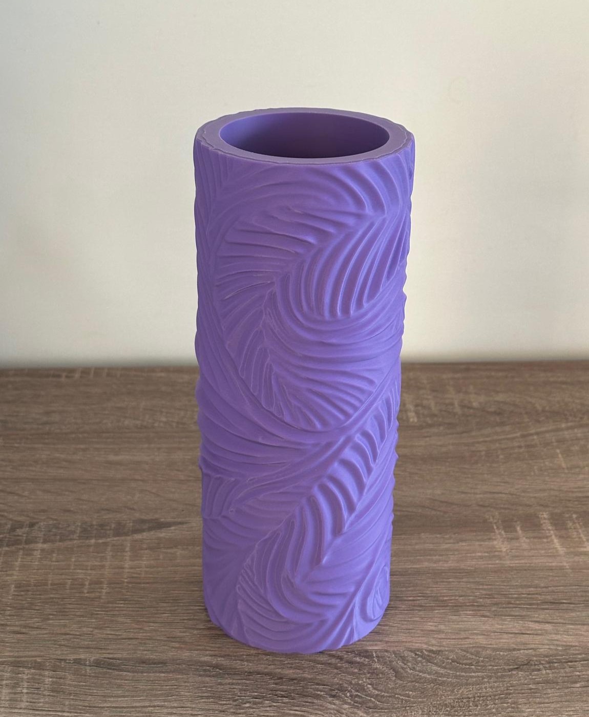 Rolo de espuma roxo com textura ondulada em cima de mesa de madeira