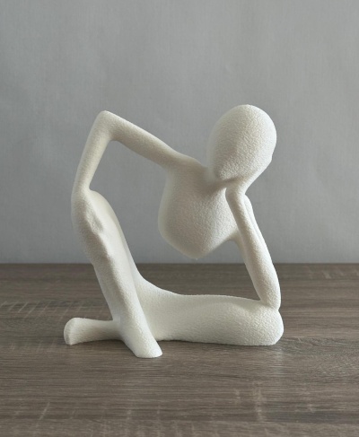 Escultura abstrata branca de figura humana sentada em madeira clara