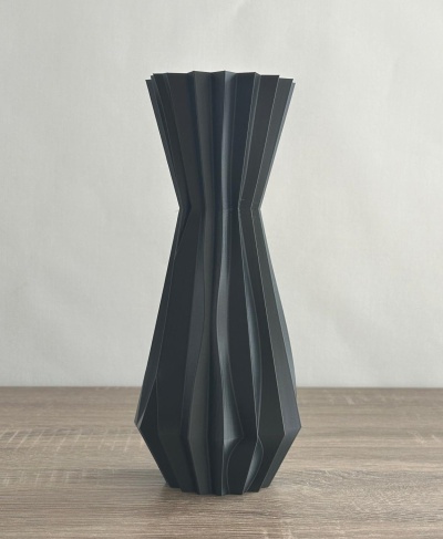 Vaso preto geométrico sobre superfície de madeira clara