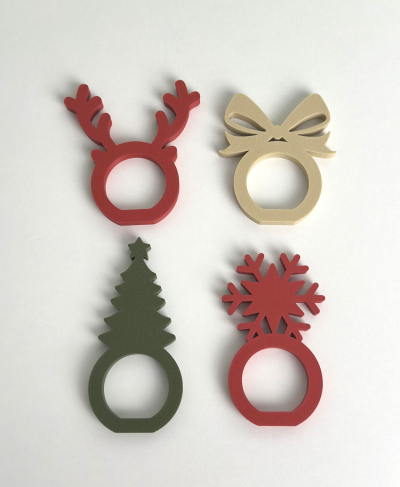 Argolas de guardanapo natalícias em madeira com formas de rena, laço, árvore e floco de neve.