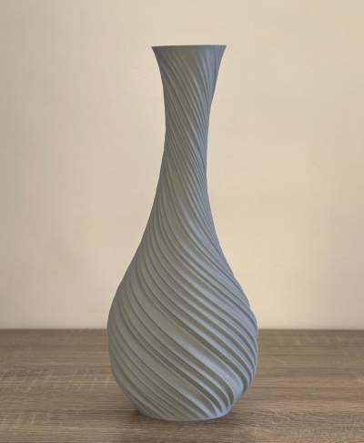 Vaso cinza claro com textura ondulada em espiral sobre mesa de madeira