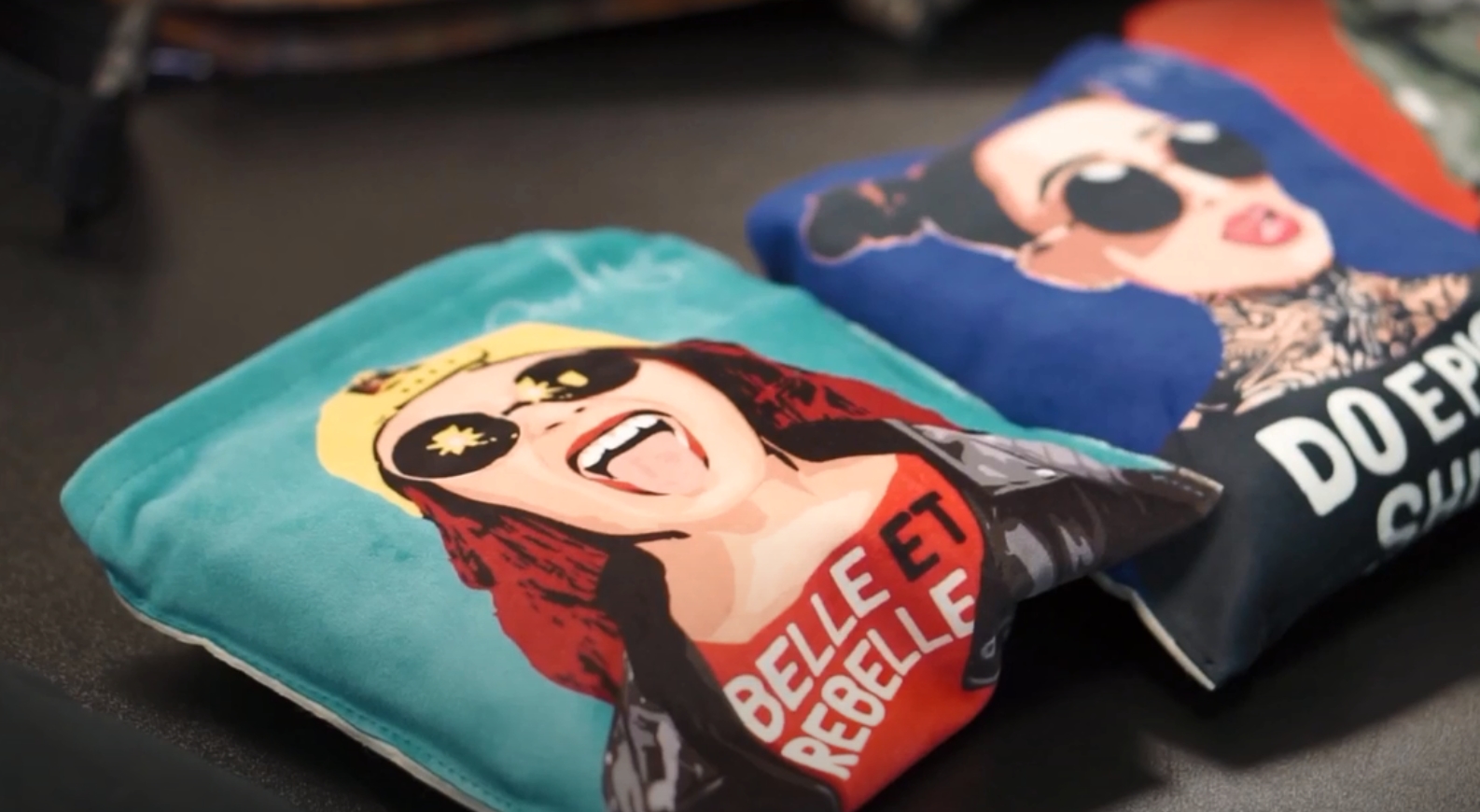 Dois edredons dobrados com imagens de mulheres e texto em português e francês.