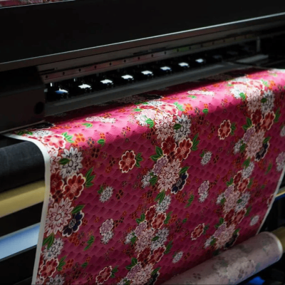 Tecido rosa com padrão floral sendo impresso numa máquina