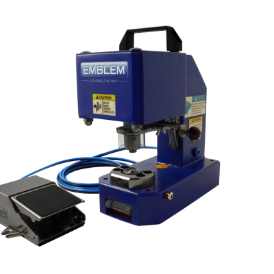 Máquina industrial azul EMBLEM com etiquetas de aviso e pedal metálico