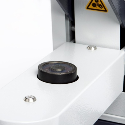 Microscópio branco com lente preta e sinal de aviso amarelo