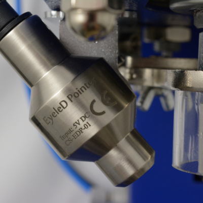 Peça metálica cilíndrica com texto e conexões em fundo azul.