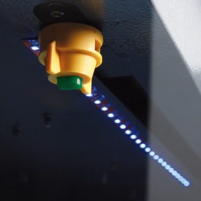 Sensor amarelo com componente verde e luzes LED azuis num teto escuro