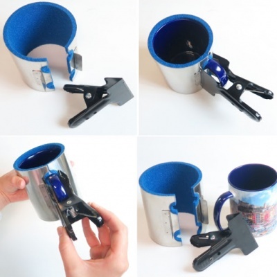 Suporte metálico com pinça para canecas, interior azul, caneca azul sendo encaixada