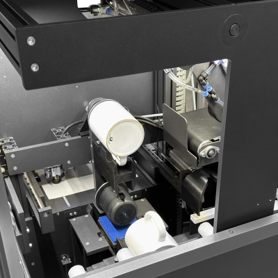 Máquina a personalizar canecas brancas em ambiente industrial