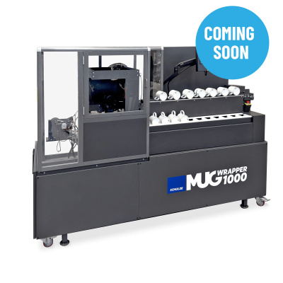 Máquina industrial para embrulhar canecas preta e cinza com canecas brancas alinhadas e texto promocional.