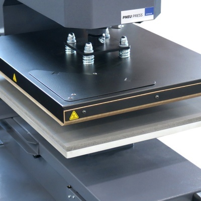 Prensa preta com molas e etiqueta PNED PRESS numa bancada cinzenta